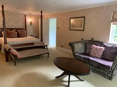 a bedroom with a bed and a couch and a table at Boscundle Manor in St Austell