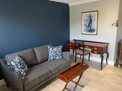 a living room with a couch and a desk at Boscundle Manor in St Austell