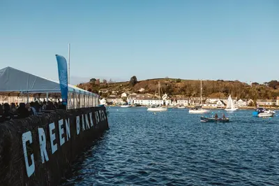 a group of people sitting on a pier next to the water at Greenbank Hotel in Falmouth