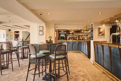 a bar in a restaurant with stools at Pier House in St Austell
