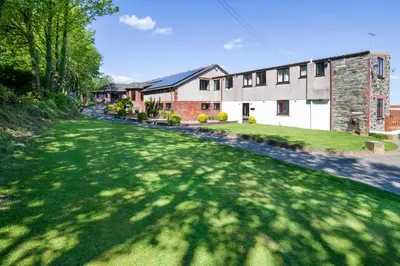 a house with a green lawn in front of a building at Trethorne Hotel & Golf Club in Launceston