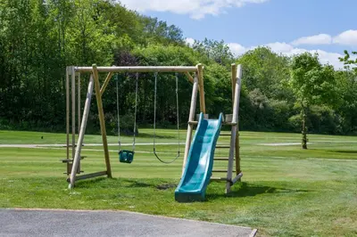a playground with two swings in a park at Trethorne Hotel & Golf Club in Launceston