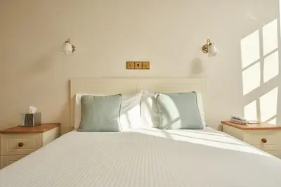 a bedroom with a large white bed with blue pillows at Great Western in Newquay