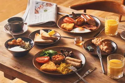 a wooden table with plates of breakfast food on it at Great Western in Newquay