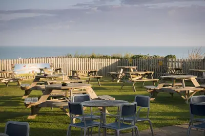 a group of picnic tables and chairs in the grass at Great Western in Newquay