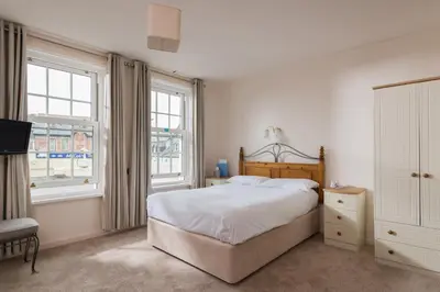 a bedroom with a large bed and two windows at Great Western in Newquay