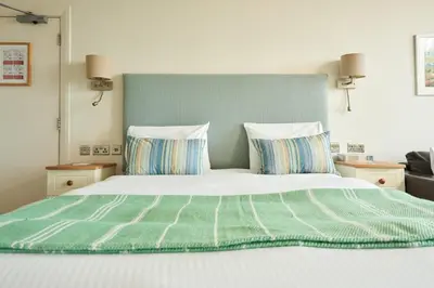 a bed with a green headboard and two pillows at Great Western in Newquay