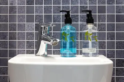 a bathroom sink with two soap bottles on it at Oasis House in Falmouth