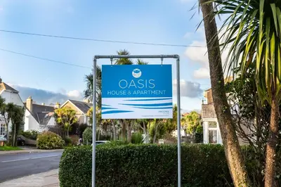 a sign for anolis house and beach night at Oasis House in Falmouth