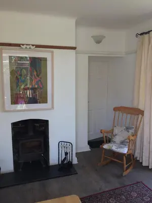 a living room with a chair and a fireplace at The garden apartment in St Ives