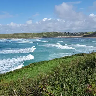 a view of a body of water with waves at For the Shore, Fistral Beach Newquay - 2 Bed 2 bath - Private Parking with garage for 2 vehicles in Newquay