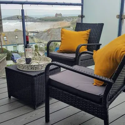 two chairs and a table on a balcony with a view at For the Shore, Fistral Beach Newquay - 2 Bed 2 bath - Private Parking with garage for 2 vehicles in Newquay