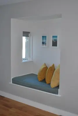 a bed in a white room with yellow pillows at For the Shore, Fistral Beach Newquay - 2 Bed 2 bath - Private Parking with garage for 2 vehicles in Newquay