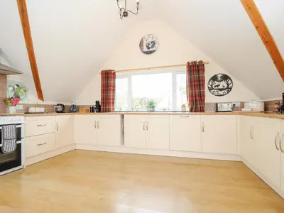 a kitchen with white cabinets and a window at Treview in Launceston