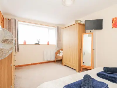a bedroom with a bed and a tv on the wall at Treview in Launceston
