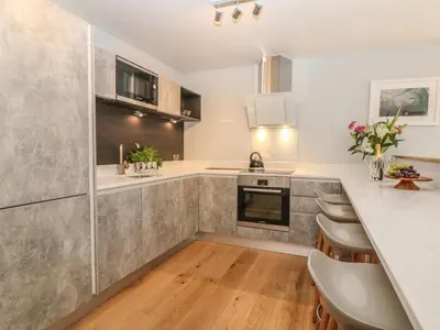 a kitchen with stainless steel appliances and wooden floors at Dexter in Penryn