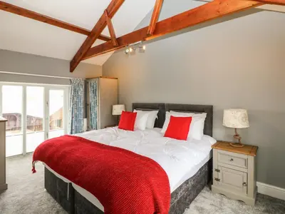 a bedroom with a large bed with red pillows at Argal in Penryn