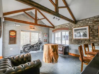 a living room with a table and a motorcycle in it at Argal in Penryn