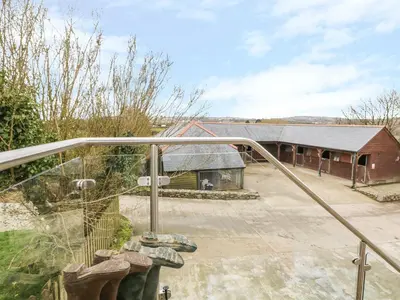 a balcony with a view of a barn at Argal in Penryn