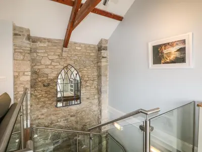 a staircase in a house with a stone wall at Helford in Penryn