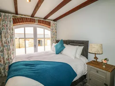 a bedroom with a large bed with a window at Helford in Penryn