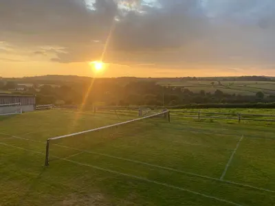 a tennis court with the sunset in the background at Helford in Penryn
