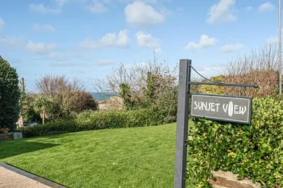 a street sign in front of a green yard at Sunset View in Newquay