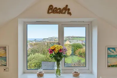a vase of flowers sitting on a window sill at Sunset View in Newquay
