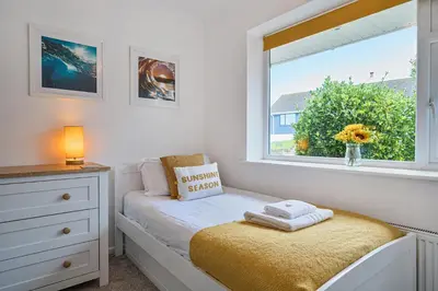 a bedroom with a window and a bed with a window seat at Sunset View in Newquay