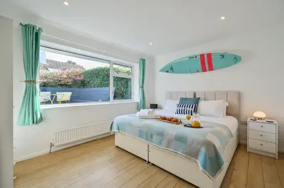 a bedroom with a bed with a surfboard on the wall at Sunset View in Newquay