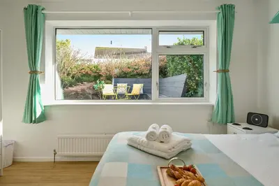 a bedroom with a bed and a large window at Sunset View in Newquay
