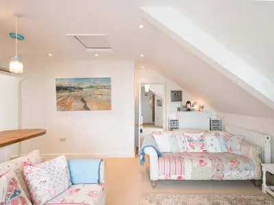 a living room with a couch and a table at Spiral View in Perranporth