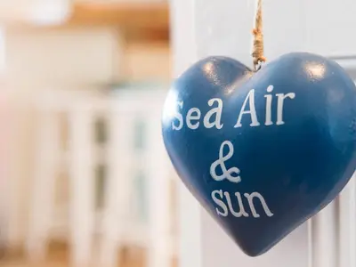 a blue heart shaped object with the words sea air and sun at Spiral View in Perranporth