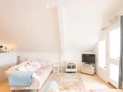 a living room with a couch and a tv at Spiral View in Perranporth