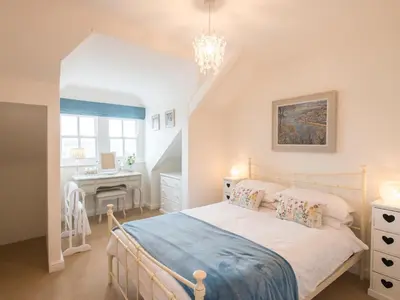 a bedroom with a bed and a desk at Spiral View in Perranporth