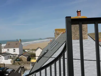 a balcony with a view of the ocean and a beach at Spiral View in Perranporth