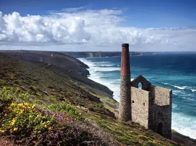 an old building on a hill next to the ocean at Mithian Cottage in St. Agnes