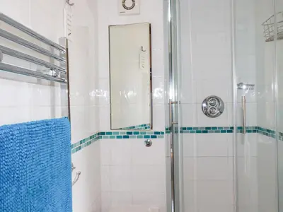 a bathroom with a shower and a mirror at Mithian Cottage in St. Agnes