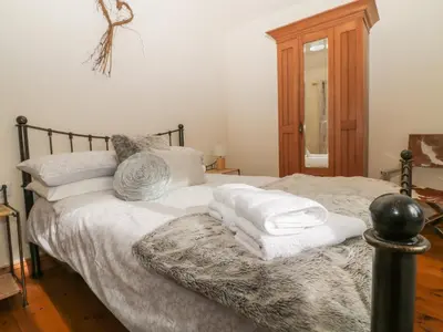 a bedroom with a bed with towels on it at Honeysuckle Cottage in Helston