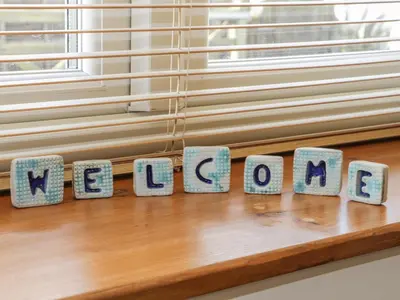 a window sill with the word welcome spelled out in stone letters at Honeysuckle Cottage in Helston