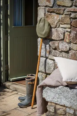 a hat and a cane leaning against a stone wall at The Granary at Cornish Barn Holidays in Truro