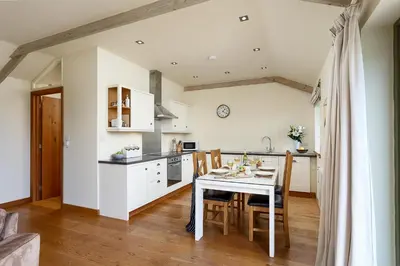 a kitchen and dining room with a table and chairs at The Granary at Cornish Barn Holidays in Truro