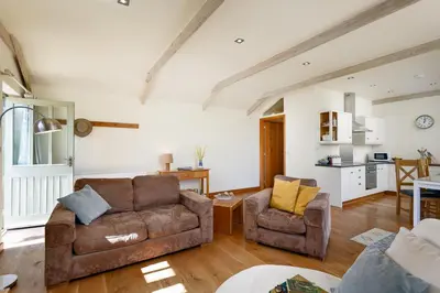 a living room with a couch and two chairs at The Granary at Cornish Barn Holidays in Truro