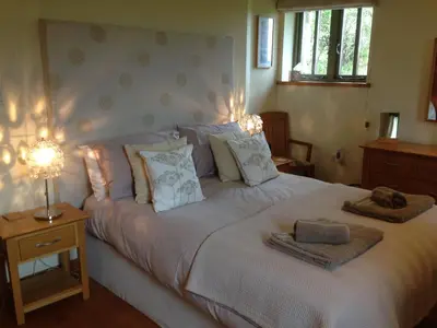a bedroom with a large bed with two towels on it at The Granary at Cornish Barn Holidays in Truro