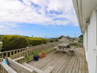 a wooden deck with a bench and a picnic table at Bethany Bay View in Cubert