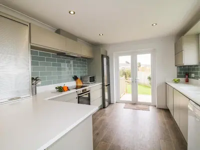 a kitchen with white counters and a large window at Bethany Bay View in Cubert