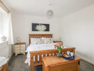 a bedroom with a bed and a table with flowers on it at Bethany Bay View in Cubert