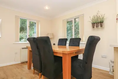 a dining room with a wooden table and black chairs at Bramble Cottage in Falmouth