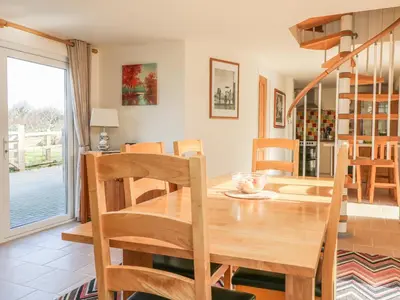 a dining room with a wooden table and chairs at Higher Kernick Stable in Bodmin