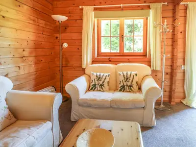 a living room with two couches and a table at Pond Cabin in Stithians